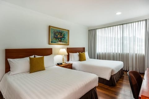 Relax in a sunlit bedroom with crisp linens and space.
