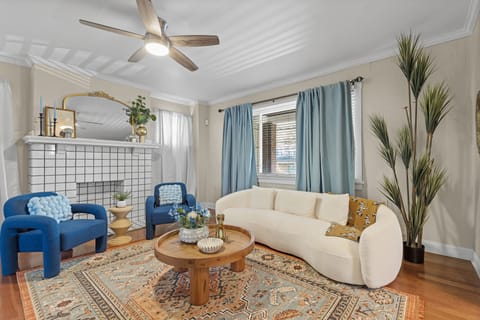 Living room with plush couches, fireplace, and ceiling fan
