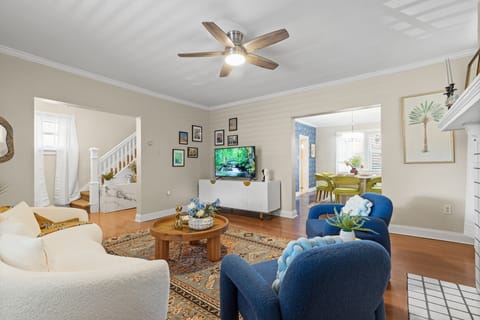 There is a TV and ceiling fan in the living room