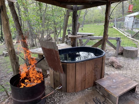 Wood fire heated hot tub just behind the camper.