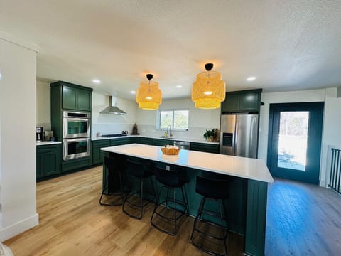 Large, open-concept kitchen with large island and overlooks bottom floor. 
