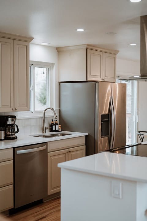 - Stainless steel fridge, dishwasher, and sink keep your essentials cool, clean, and convenient
- Brew your morning coffee right by the window with serene natural light
- Spacious quartz counters and classic cabinetry elevate everyday cooking