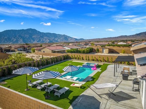 Elevated view of the backyard showing the pool, spa & surrounding space designed for outdoor fun.