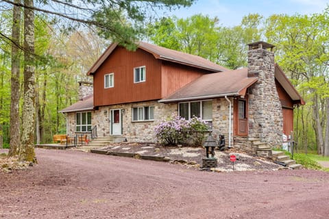A charming cabin tucked among tall trees, blending rustic stone and wood elements for the ultimate mountain escape. A peaceful getaway with nature all around.