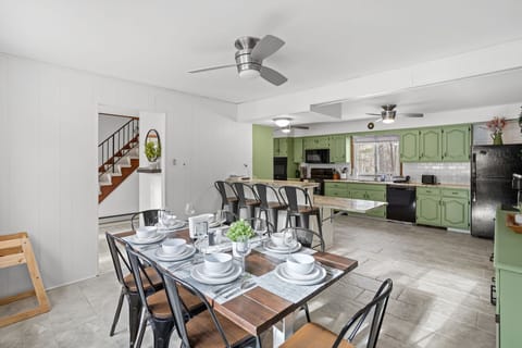  A unique mix of vintage charm and modern convenience, with bold green cabinetry and open shelving.