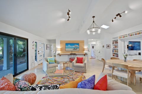Sundowner Main Living Room - Vaulted ceilings, colorful seating, and wall-to-wall sliders set up the main gathering space.