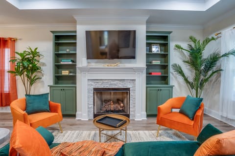 Living room with fireplace, indoor plants, and shelf rack with board games