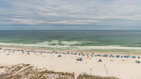 This stunning beachfront view showcases inviting sandy shores lined with colorful umbrellas, perfect for relaxation and fun