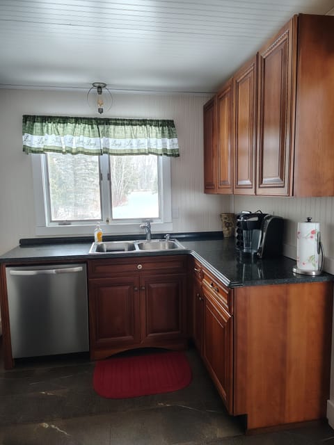 Kitchen sink with view of yard.  Keurig coffee maker.