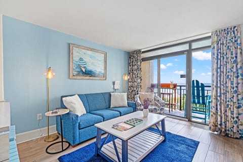 Cozy oceanfront living room with a sleeper sofa, coastal décor, and direct access to a private balcony. Enjoy panoramic views of North Myrtle Beach and overlook the resort’s beachfront pools in this bright, relaxing space.