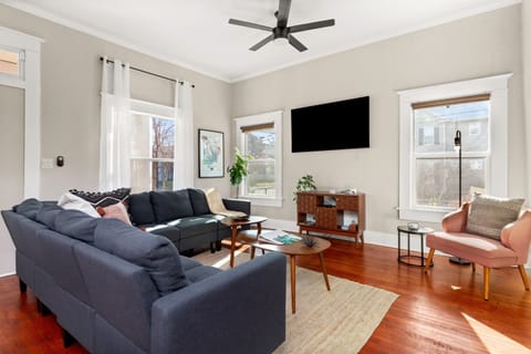 Living room serenity: where the glow of the TV meets the comfort of the sofa, framed by the warmth of natural light!