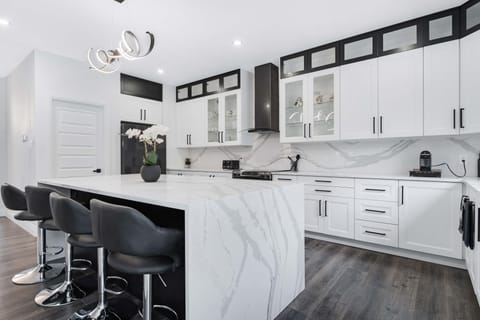 Sleek & modern kitchen featuring high end appliances & a spacious quartz island