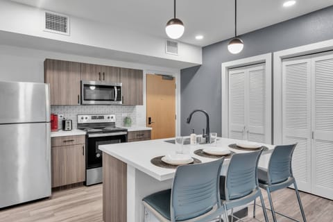 The kitchen area also has a stackable washer/dryer stored behind the luvered doors.