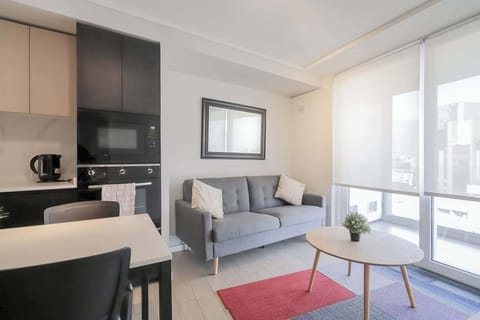 Bright and cozy living area with modern amenities and stunning city views, perfect for a relaxing stay.