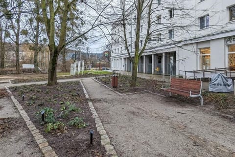 Courtyard area with benches, trees, and garden paths, promoting relaxation and outdoor enjoyment.