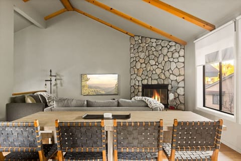 Enjoy cozy meals with a view – the dining table overlooks a warm fireplace and the inviting living room, creating the perfect atmosphere for relaxation and connection.