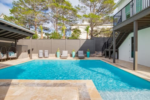 Dive into your private oasis with crystal-clear waters, comfortable lounge chairs, and lush greenery creating the perfect poolside retreat.