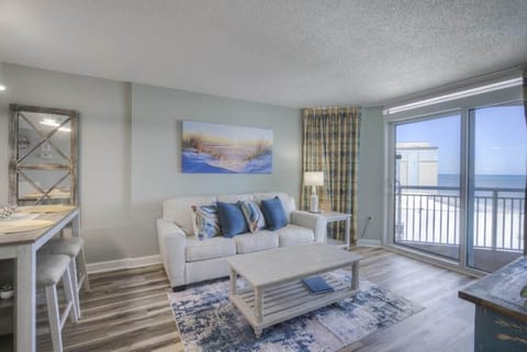 Living Room with Large Wall Mounted TV and Sliding Doors to Private Balcony