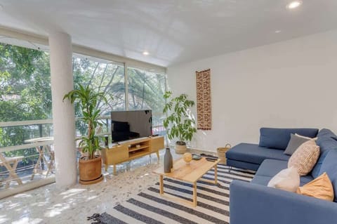 Sala de estar con smart TV, apps como Netflix, Youtube, Prime Video, etc. A un lado del balcón con un pequeño desayunador.