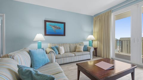 Relax in this coastal-inspired living room with ocean views through the balcony door.