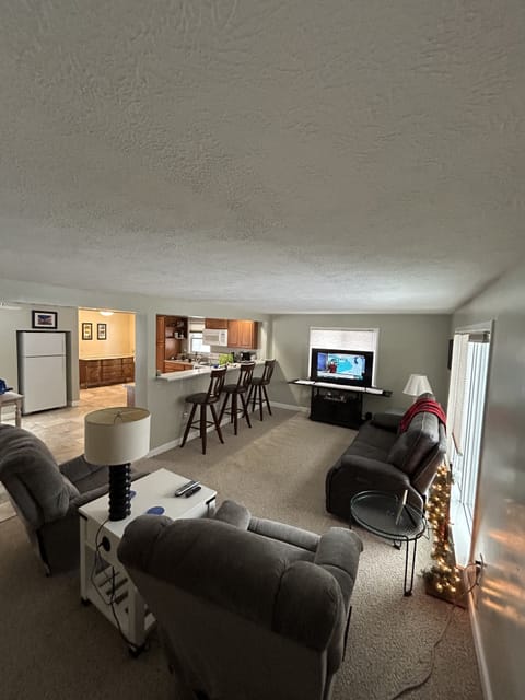 View from the stair case showcasing the kitchen and living room.