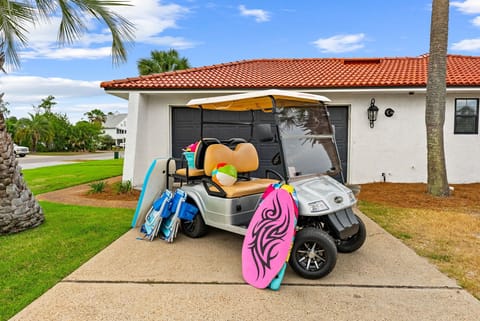 The property includes a golf cart stocked with beach gear including boogie boards, beach chairs, and toys for guest convenience during their stay.