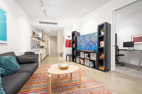 Bright and inviting living area with smart TV and stylish shelving.