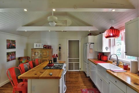 Equipped with full size appliances large sink and island bar lend a farmhouse ambiance to the kitchen.