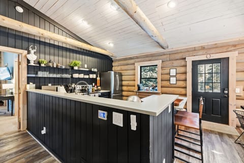 Social Cooking Bar — Sleek appliances, exposed beams, and a wraparound bar—perfect for cooking while your crew keeps you company. 🍷👨‍🍳