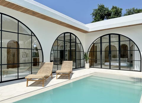 Large swimming pool with two lounge chairs on the deck