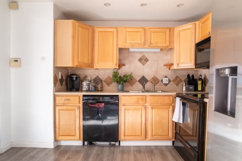 Compact and fully equipped kitchen with beech colored cupboard