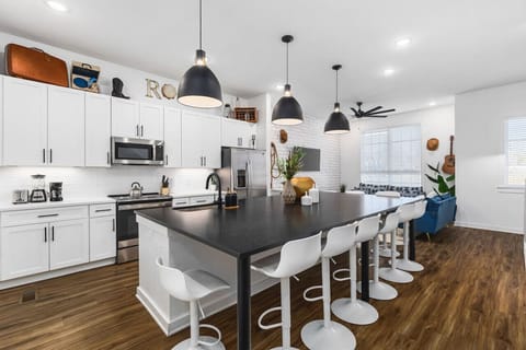 Huge kitchen on the main floor of the house with  a massive island, seating for 10, and all the appliances / supplies you'd need to cook a meal.