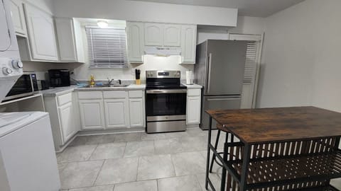 Kitchen: Our spacious kitchen is equipped with ample counter space, storage, stainless steel appliances, and an island table.