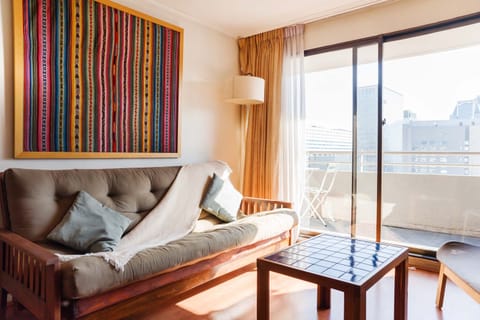 Relax in this bright and cozy living area with a stunning city view from the balcony, perfect for unwinding after a day of exploring.