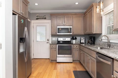 Fully Stocked Kitchen - The kitchen features stainless appliances which include a smooth cooktop range, built-in microwave, dishwasher, and side by side refrigerator with ice and water in the door. Each cabinet is stocked with all dishes and cookware needed for preparing your meals.