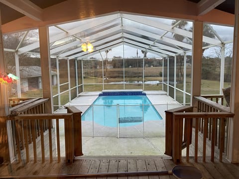 Sparkling POOL  from the upper deck all under a screened enclosure.