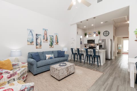 Settle into your bright open living space where coastal artwork and comfy seating create the perfect beach house vibe for your getaway.
