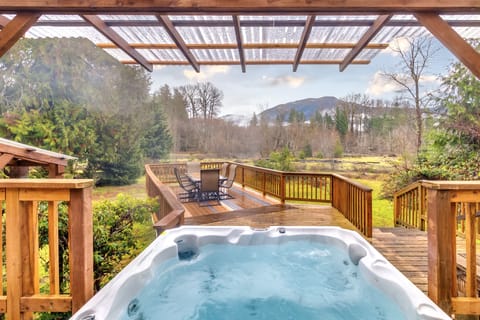 Covered hot tub overlooking private backyard.