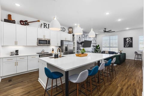 Huge kitchen on the main floor of the house with  a massive island, seating for 9, and all the appliances / supplies you'd need to cook a meal.