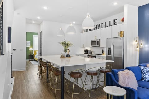 Huge kitchen on the main floor of the house with  a massive island, wine cooler, tons of seating, and all the appliances / supplies you'd need to cook a meal.