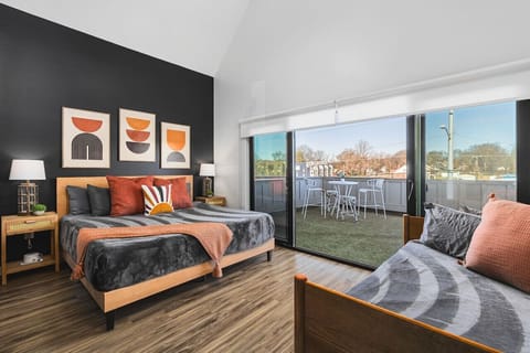 Upstairs bedroom #3 with a King bed, twin + trundle bed, and large sunny patio space with outdoor furniture & cornhole.