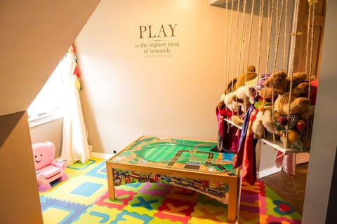 The play space features a train table, zoo and many many toys.