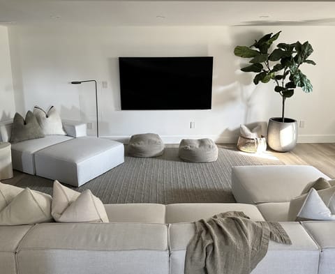 Inviting lower-level media room boats a 75" smart TV and large sectional.