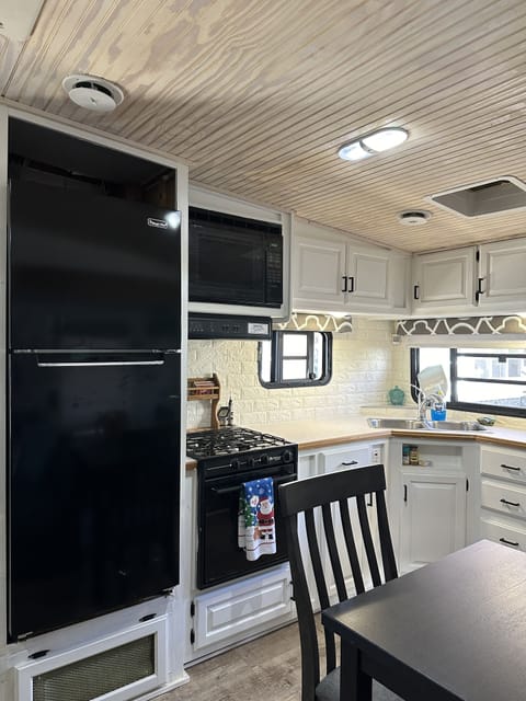Kitchen with large refrigerator, stove and microwave