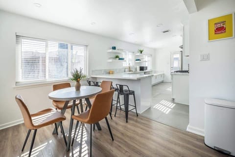 Dining Area: Clean and refreshing dining space with a high chair, great for family gatherings or quiet mornings.