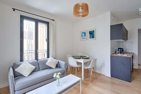 Salon avec cuisine américaine et coin repas