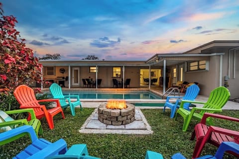 Pembroke Pines vacation rental 4 miles from Hard Rock Stadium, 4 miles from Seminole Hard Rock Casino, and 9 miles from beach
- Fire pit by the pool with colorful chairs under sunset skies  
- Perfect for outdoor evening gatherings and fun nights  

