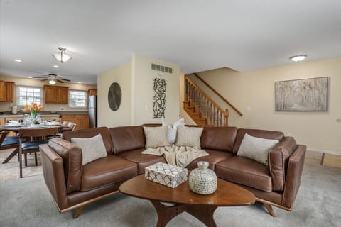 A comfy leather couch and an artsy coffee table adorn the living room, creating the perfect setting for morning hot drinks and quiet contemplation.
