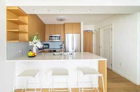 A kitchen that feels both modern and inviting. The unique dining table and chairs add a touch of personality to the space, creating a stylish atmosphere. With its neat design and calming colors, this kitchen becomes a happy spot to enjoy meals and cr