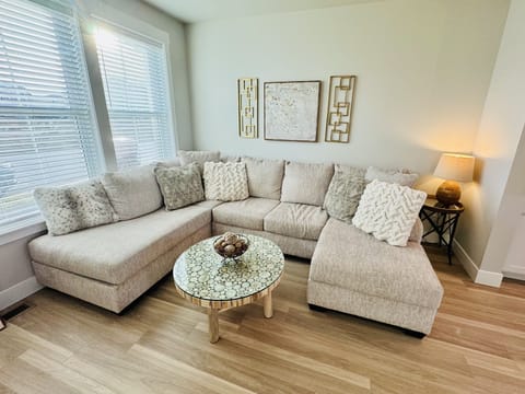 Light and bright living room with comfortable couch, coffee table and TV.